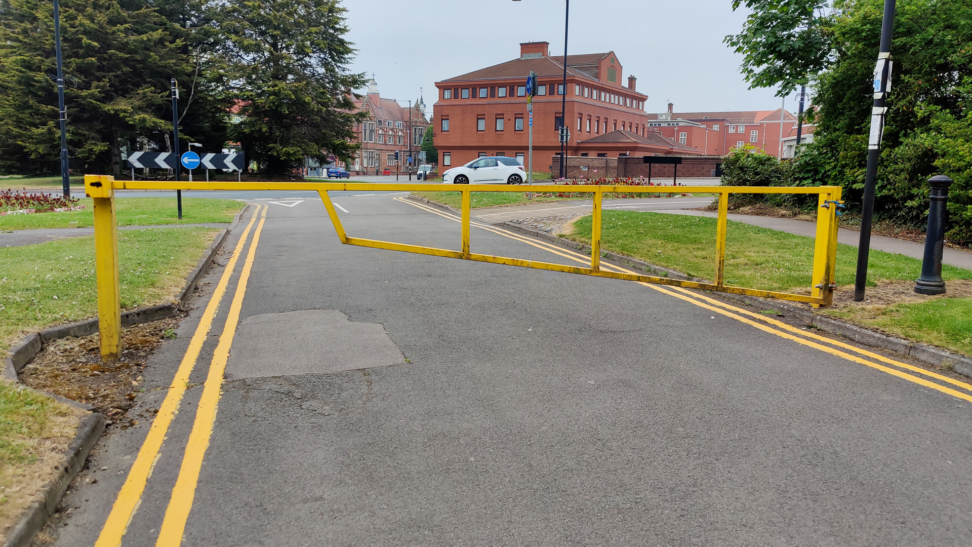 Access road secured with a closed yellow metal gate