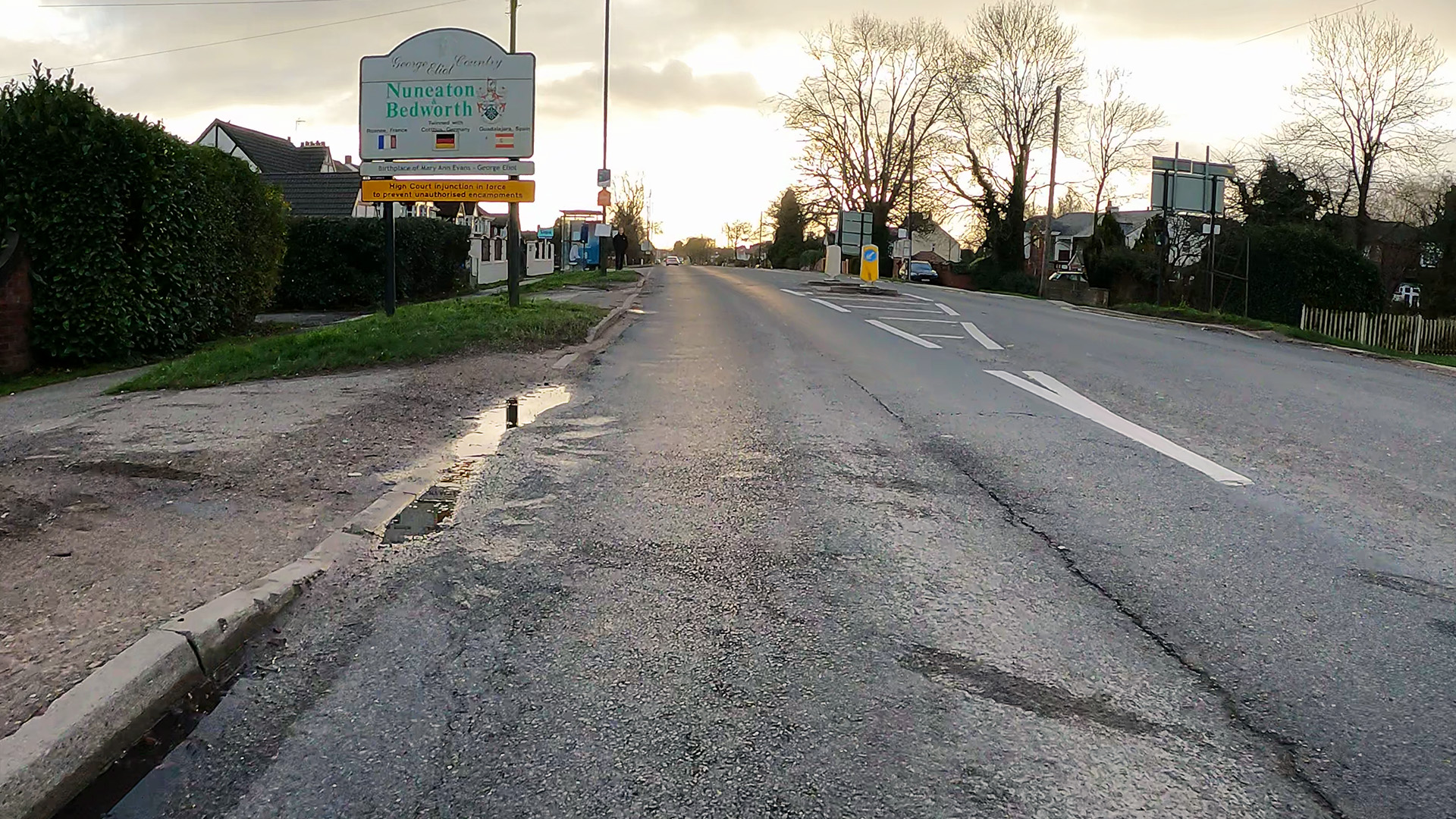A47 Long Shoot, Nuneaton (West Bound). On the left is a town boundary sign. A pedestrian island is visible in the middle of the road, presenting as a pinch point.